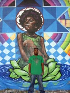 Refa One, from Oakland, California, stands in front of one of his murals, The Forces of Nature.