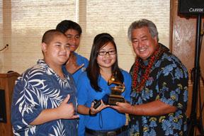 George Kahumoku, flanked by his students, receiving a Grammy Award