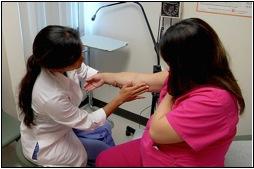 A physician professor at JABSOM OB-GYN & Women's Health conducts an exam.