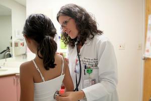Kelly Makino, MD, examines a child at the Physician Center at Mililani.
