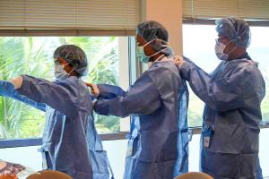 MD 2018 medical students Arcelita Imasa, Gabriel Lapid and Joel Sabugo suiting up for surgery last year.